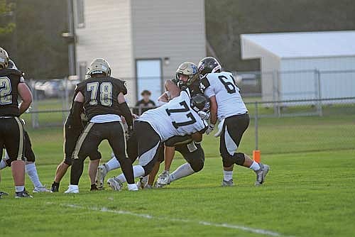Tyrone Moore (77), Aidan Bauers (behind) and Gavin LaBarge (64) tackle Hayward’s Gabe Bisonette in the end zone during the first quarter of the season opener Friday, Aug. 22 at Rod Lundberg Field in Hayward. (Photo by Brett LaBore/Lakeland Times)