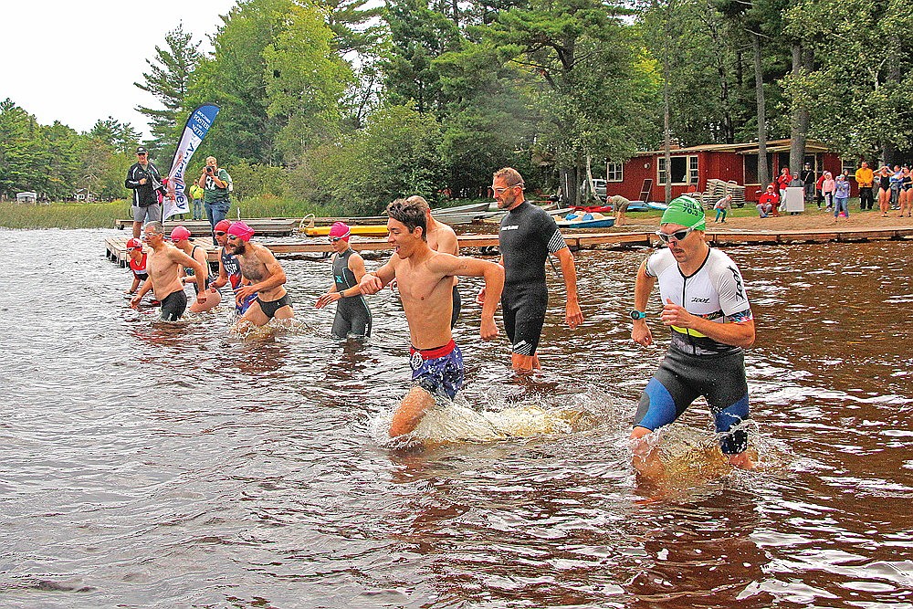 Athletes in the first wave leave the starting line to begin the swimming portion of the race.