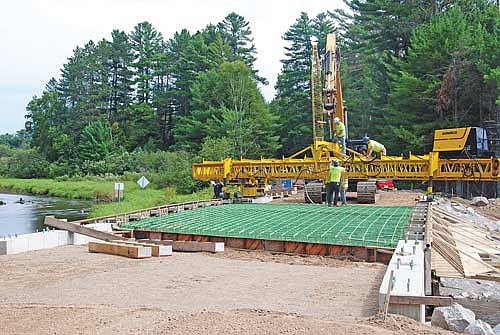 Employees with Athens-based Janke General Contractors make adjustments to a concrete finisher at the site of a new bridge on Camp 9 Road on Minocqua’s west side on Wednesday, Aug. 27. The concrete for the bridge’s deck was poured the next day. (Photo by Brian Jopek/Lakeland Times)