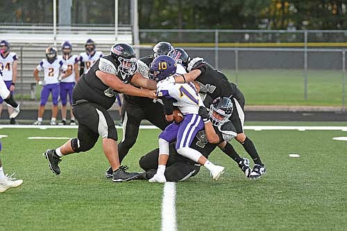 Lakeland’s quartet of defenders, from left, Tim Vazquez, Aidan Bauers, Nolan Johnson and Gavin LaBarge tackle Ashland’s Aiden Jolma in the second quarter Friday, Aug. 29 at IncredibleBank Field in Minocqua. (Photo by Brett LaBore/Lakeland Times)