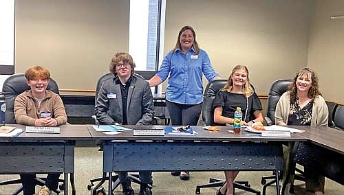 Sitting down at the table, from left, are Oneida County Youth in Governance Program student representatives Parker Lee and Matthew Carpenter (both from Rhinelander High School) and Vella Walden (from Lakeland Union High School). Standing behind the student representatives is Anne Williams, UW-Extension Oneida County 4-H Educator. Sitting on the far right is Oneida County Clerk Tracy Hartman. Williams and Hartman co-led the OCYG program Courthouse Day training. (Contributed photograph)