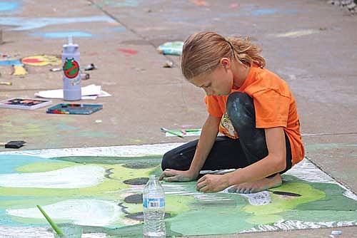 Nine-year-old Brooklynne Teeters works on her award winning frog chalk art. (Photo by Kate Reichl/Lakeland Times)