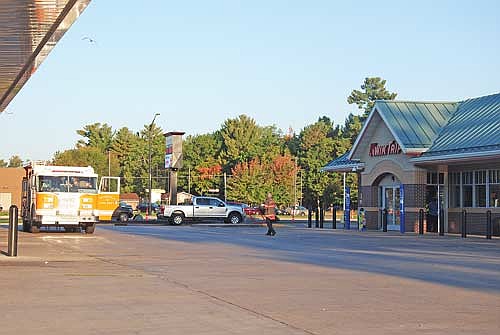 Minocqua fire chief Rich Carani walks to the Minocqua fire department’s Engine 1 parked on the platform of what was a briefly closed Minocqua Kwik Trip store the morning of Monday, Sept. 30. (Photo by Brian Jopek/Lakeland Times)