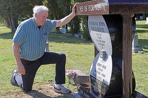Allen Grasser kneels in front of the newly installed memorial to his brother Norman Grasser on Wednesday, Sept. 24, at Forest Home Cemetery in Rhinelander. (Photo by Kate Reichl/Lakeland Times)