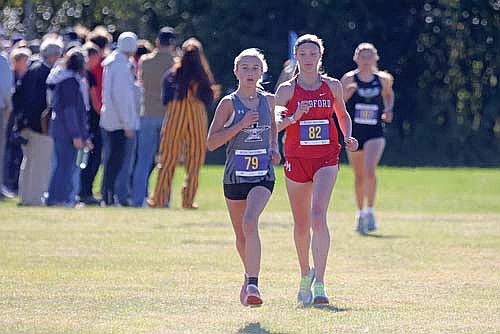 Emerson Rubo runs ahead of Medford’s Lindsay Kahn in the Hatchet Invite Saturday, Oct. 11 at Tomahawk High School. Kahn would go on to win with Rubo 6.2 seconds behind with a personal-record time of 19:18.4. (Photo by Jeremy Mayo/River News)