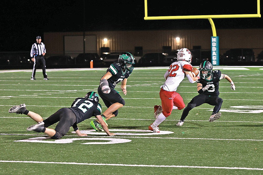 Rhinelander’s Ryley Hull (3), Myles Eagleson (0) and Judson O’Malley (12) attempt to tackle Medford’s Will Wojcik during the second quarter of a GNC football game at Mike Webster Stadium Friday, Oct. 10. The Hodags, after allowing more than 275 yards on the ground each of the last two weeks, will be tested again Friday night against a Merrill team that’s averaging more than 211 yards per game on the ground. (Bob Mainhardt for the River News)