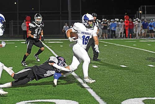 Tyson Redman tries to bring down Merrill’s Kanin Jahnke in the first quarter of a conference game Friday, Sept. 26 at IncredibleBank Field in Minocqua. (Photo by Brett LaBore/Lakeland Times)