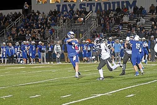 Merrill’s Cole Rudie throws a pass with pressure from Hudson Gehl in the second quarter of a WIAA Division 3, Level 1 playoff game Friday, Oct. 24 at Jay Stadium in Merrill. Rudie threw and ran for a touchdown in Merrill’s 38-12 win. (Photo by Brett LaBore/Lakeland Times)