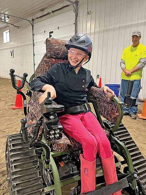 Nineteen-year-old Auroralee Wade’s eyes light up as she rides the new all-terrain wheelchair that was unveiled at Scholl Community Impact Group’s Oct. 18 horse show. Access to the wheelchair is managed by Access Ability Wisconsin and provided through SCIG in Winchester. (Contributed photograph)