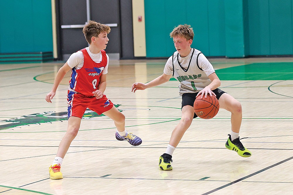 Coltyn Anderson handles the ball against a Horace Mann defender during the eighth-grade A game at the JWMS gymnasium. (Bob Mainhardt for the River News)