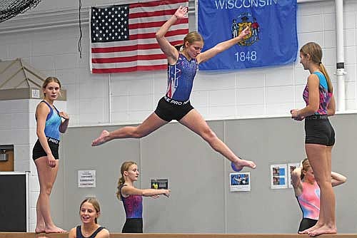 Gymnasts, from left, Malin Awker, Grace Elbe and a leaping Jenna Friedrich take part in the first day of practice Tuesday, Nov. 11 at Lakeland Union High School in Minocqua. (Photo by Brett LaBore/Lakeland Times)