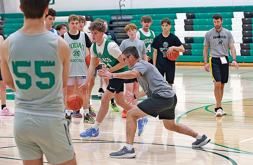 Rhinelander High School boys’ basketball coach Derek Lemmens demonstrates a drill will senior Devon Feck during practice in the Jim Miazga Community Gymnasium Monday, Nov. 17. Monday marked the first day of official practice for high school boys’ basketball, boys’ swimming and wrestling teams in the state. (Bob Mainhardt for the River News)