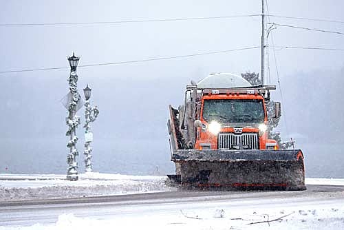 An Oneida County snowplow clears U.S. Highway 51 on Wednesday, Nov. 26, in downtown Minocqua, as snow falls past utility poles decorated for Christmas. The season’s first major storm, which began overnight and continued into Thanksgiving eve day, brought hazardous travel and power outages. (Photo by Kate Reichl/Lakeland Times)