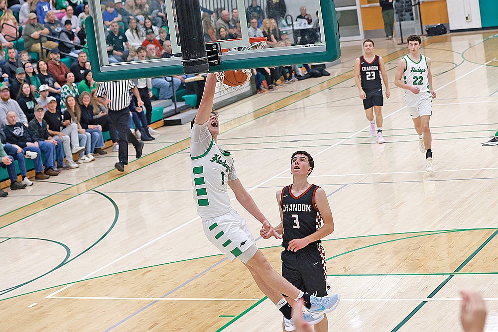 Rhinelander’s Jatyn Barkus dunks the basketball ahead of Crandon’s Logan Jaeger during the first half of a non-conference boys’ basketball game at the Jim Miazga Community Gymnasium Tuesday, Nov. 25. The Hodags had four players score in double figures, including Barkus with 12 points, in an 83-25 win over the Cardinals. (Bob Mainhardt for the River News)