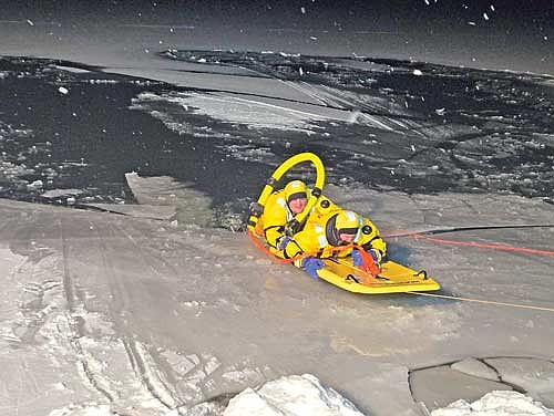 Eric Carlson, assistant chief of the Minocqua fire department, plays the role of “victim” as he lays on the rescue sled and Frankie Plahuta, one of the department’s newest members, the “rescuer”during one of the practical exercises for ice rescue training on Monday, Dec. 1. (Contributed photograph)