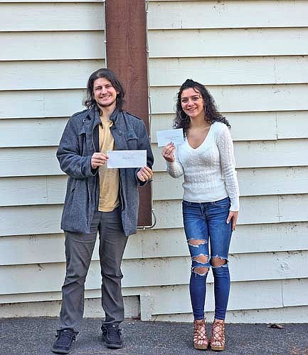 Frederick Place house staff, Alec Klabunde and Ashlynn Klabunde display recently received financial gifts in front of the St. Germain Community Church. (Contributed photograph)