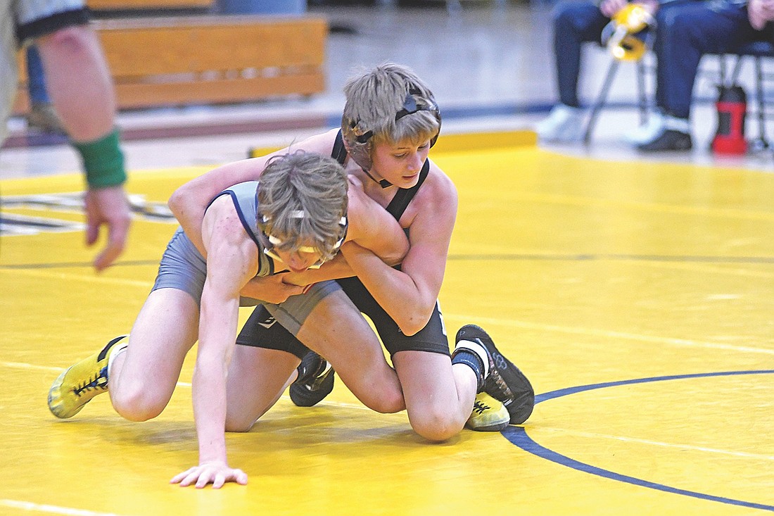 Mason Trapp, right, grasps Tomahawk’s Owen Oates in the 113-pound weight class in the season opener Thursday, Dec. 4 at Tomahawk High School. Trapp won his first-ever high school wrestling match. (Photo by Brett LaBore/Lakeland Times)