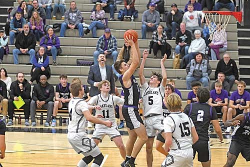 Mosinee’s Treve Stoffel looks to make a play in the paint surrounded by a trio of Lakeland players in Brooks Lenz (4), Jackson Burnett (11) and Lincoln Friedley (5) in the second half of the season opener Friday, Dec. 5 at Ted Voigt Court in Minocqua. Stoffel led all players with 25 points. (Photo by Brett LaBore/Lakeland Times)