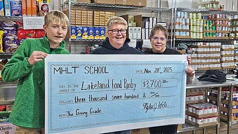 MHLT student and National Junior Honor Society member Myles Koele, left, presents a check for $3,700 to Lakeland Pantry board member Ginny Buzzell and Lakeland Pantry director Lorna Springate. (Contributed photograph)