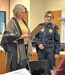 Eagle River city administrator Robin Ginner reads from a resolution honoring retiring Eagle River police chief Christine Dobbs during the Dec. 10 Eagle River city council meeting. (Photo by Fred Williston/Lakeland Times)