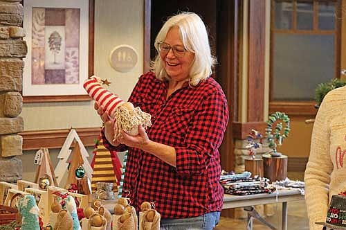 Diane Dodge does some holiday shopping during the Holiday Craft Fair on Friday, Dec. 12, at Rennes Health and Rehab Center in Rhinelander. (Photo by Kate Reichl/Lakeland Times)
