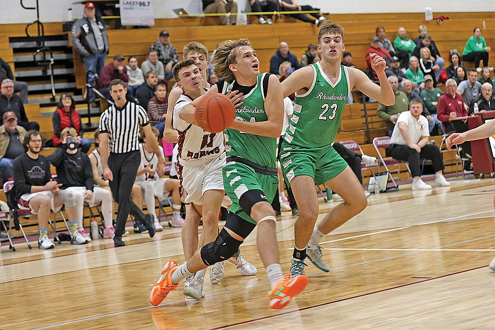 Rhinelander’s Abe Gretzinger is held by Antigo’s Isaac Buchman while teammate Evan Shoeder (23) looks on during the first half of a GNC boys’ basketball game in Antigo Friday, Dec. 12. Gretzinger and Shoeder combined for 33 points and 21 rebounds in the Hodags’ 62-42 victory. (Bob Mainhardt for the River News)