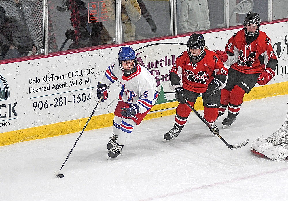 Reese Retallick looks up at her options with possession of the puck in the first period of a game against Medford Tuesday, Dec. 16 at the Eagle River Recreation Association Sports Arena. (Brett LaBore/Lakeland Times)