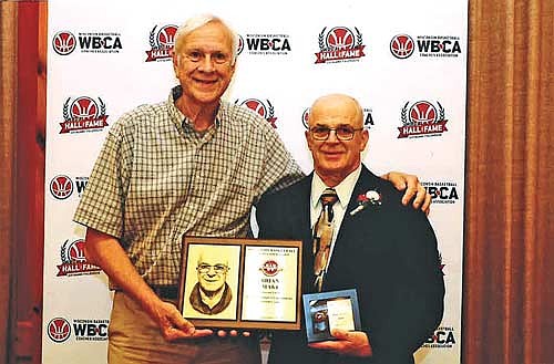 Brian Maki, right, shares a photo with Ted Voigt during the Wisconsin Basketball Coaches Association Hall of Fame Banquet Sept. 28 at the Glacier Canyon Lodge of the Wilderness Resort in Wisconsin Dells. Maki was inducted into the WBCA Hall of Fame as an assistant coach. (Contributed photograph)