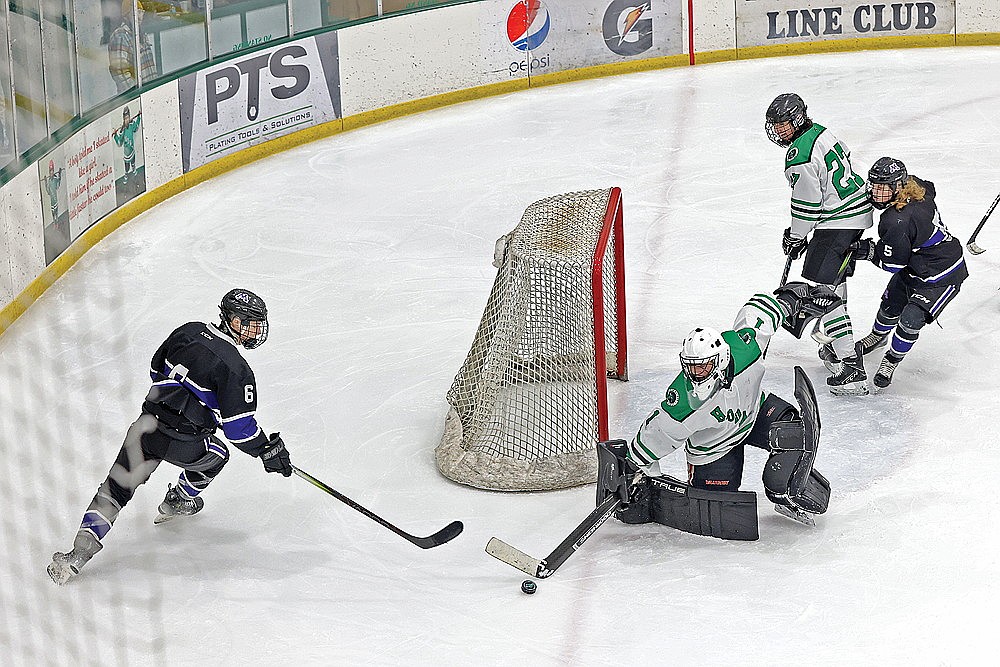 Rhinelander goalie Connor McGee reaches to knock a puck away from Mosinee’s Tyler Baars in the third period of a GNC boys’ hockey game at the Rhinelander Ice Arena Monday, Jan. 12. Baars scored four times for Mosinee while McGee recorded a career-high 51 saves as Mosinee defeated Rhinelander, 8-1. (Bob Mainhardt for the River News)
