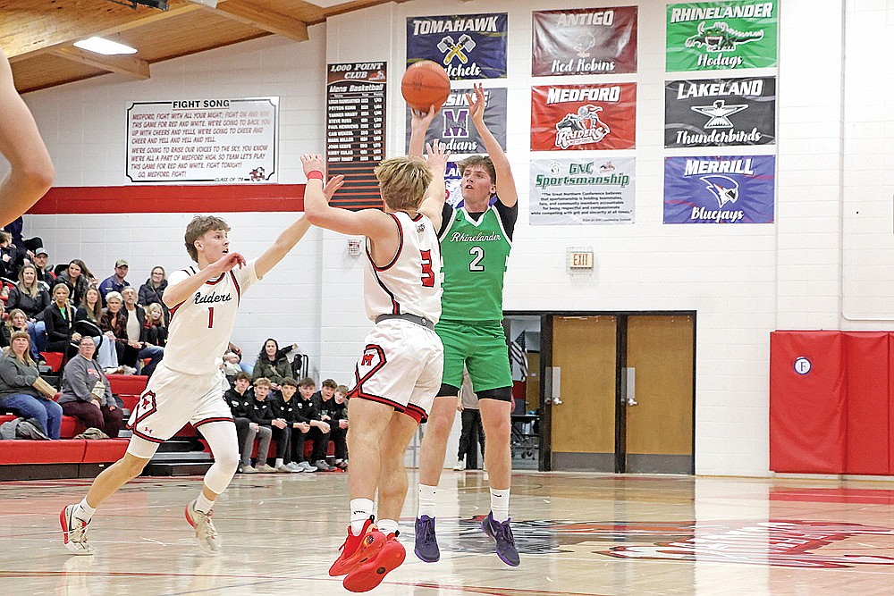 Rhinelander’s Devon Feck attempts a 3 over Medford’s Nick Krause (1) and Will Wojcik (3) during the first half of a GNC boys’ basketball game in Medford Thursday, Jan. 22. Feck scored a game-high 23 points in the Hodags’ 76-57 win. (Jeremy Mayo/River News)