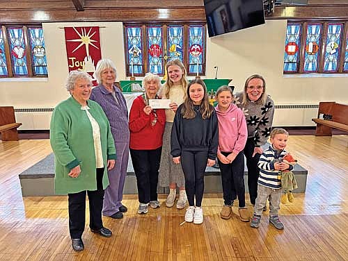 Pictured for the check presentation are, from left, Carole Hansen, Nancy Eisle, Ginger Chrobach representing the Rhinelander Area Food Pantry and Chloe Pudlowski, Kinley Pudlowski, pastor Kari Vadis and Henry Sattler representing Trinity Lutheran’s Children’s Offering. (Contributed photograph)
