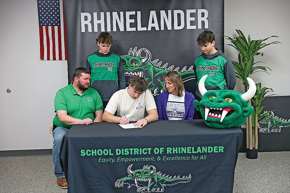 Rhinelander High School’s Caden Sieker, center, signs a National Letter of Intent to play college football at Winona State University, a NCAA Division II school in Winona, Minn., at RHS Wednesday, Feb. 4. Sieker is joined seated at the table by his parents, Andrew and Rachel, and standing behind by his younger brothers, Micah and Easton. (Bob Mainhardt for the River News)