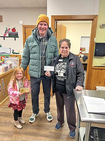 Bottled Bean owner Tyler Knobeck and his daughter Eliza present a $2,700 check to Lakeland Pantry director Lorna Springate. (Contributed photograph)
