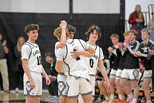 Deklan McQuade hugs Evan Zoch (1) with Tucker Moon (10) and Benny Gahler (0) looking on in the opening moments of Lakeland’s non-conference game against Wausau East Tuesday, Feb. 17 at Ted Voigt Court in Minocqua. Zoch made his first start of the season on Senior Night and left to a standing ovation from Lakeland’s crowd. (Photo by Brett LaBore/Lakeland Times)
