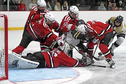 Lawson Bain, far right, gets a stick on the puck before Shawano/Bonduel goalie Tyson Lyons can reach it to score the game-winning goal in the second overtime of a WIAA Division 2 regional final game Thursday, Feb. 19 at the Lakeland Hawks Ice Arena in Minocqua. (Photo by Brett LaBore/Lakeland Times)