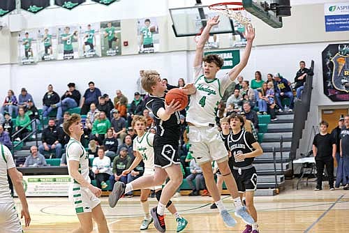 Jackson Burnett hangs in midair against the contest of Rhinelander’s Jatyn Barkus in the first half of a conference game Friday, Feb. 20 at the Jim Miazga Community Gymnasium in Rhinelander. Burnett tied a game high with 19 points. (Photo by Bob Mainhardt for the River News)