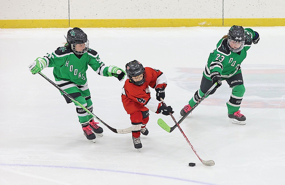 Jessa Flick, left, and Saylor Trapp (23), right, defend an Amery player during a game Friday, Feb. 20 at the Rhinelander Ice Arena.