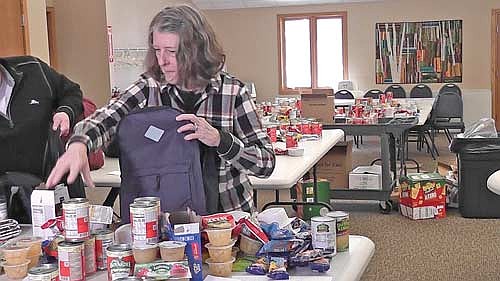 Deb Marszalek fills a backpack at Ascension Lutheran Church in Minocqua. (Contributed photograph)