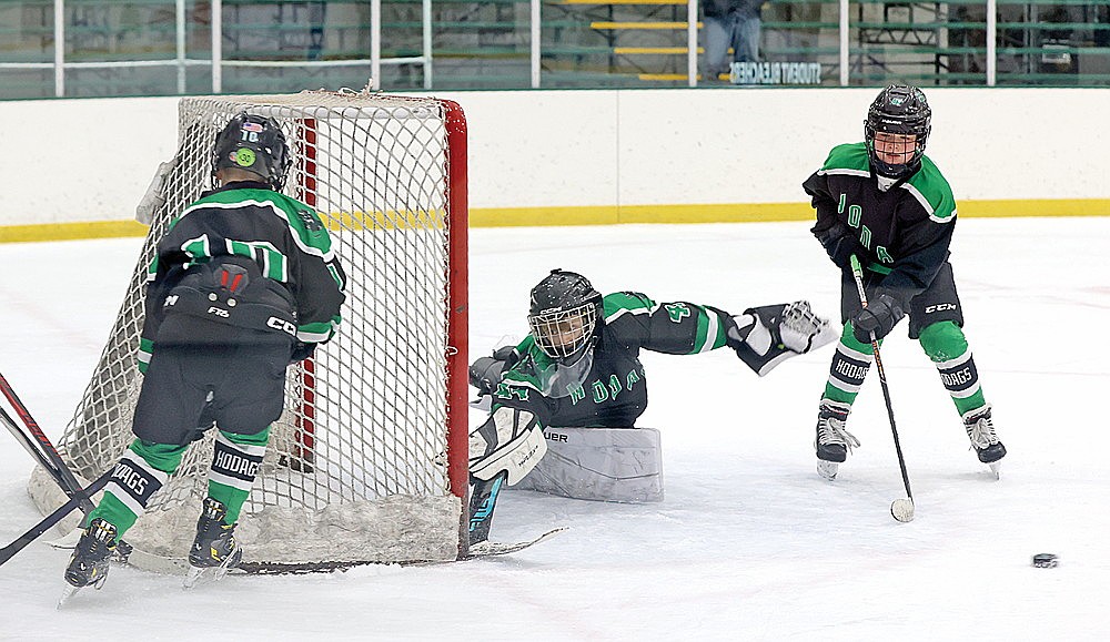 Goalie Fletcher Gehrmann scrambles to cover the post in front of teammates Ike Laggis, left, and Frankie Flanders, right, during a game against Shawano Saturday, March 7.