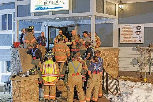 Minocqua fire and rescue chief Rich Carani, center, goes over training notes with a group of firefighters that had just finished a round of self-contained breathing apparatus (SCBA) training at The Boathouse on Monday, March 9. Photo by North Creek Photography. (Contributed photograph)