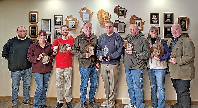 From left to right reporter Trevor Greene, graphic designer Madeleine DeFore, sports writer Brett LaBore, publisher Gregg Walker, sports editor Jeremy Mayo, reporter Brian Jopek, general manager Heather Holmes and editor Dean Hall display awards won by the Northwoods River News during the Wisconsin Newspaper Association’s annual convention held Friday, March 6 in Madison. The Northwoods River News won 25 awards, including the prestigious General Excellence category, is it took first place in Division E for the third consecutive year. (Photo by Ed Lamaide/Lakeland Times)