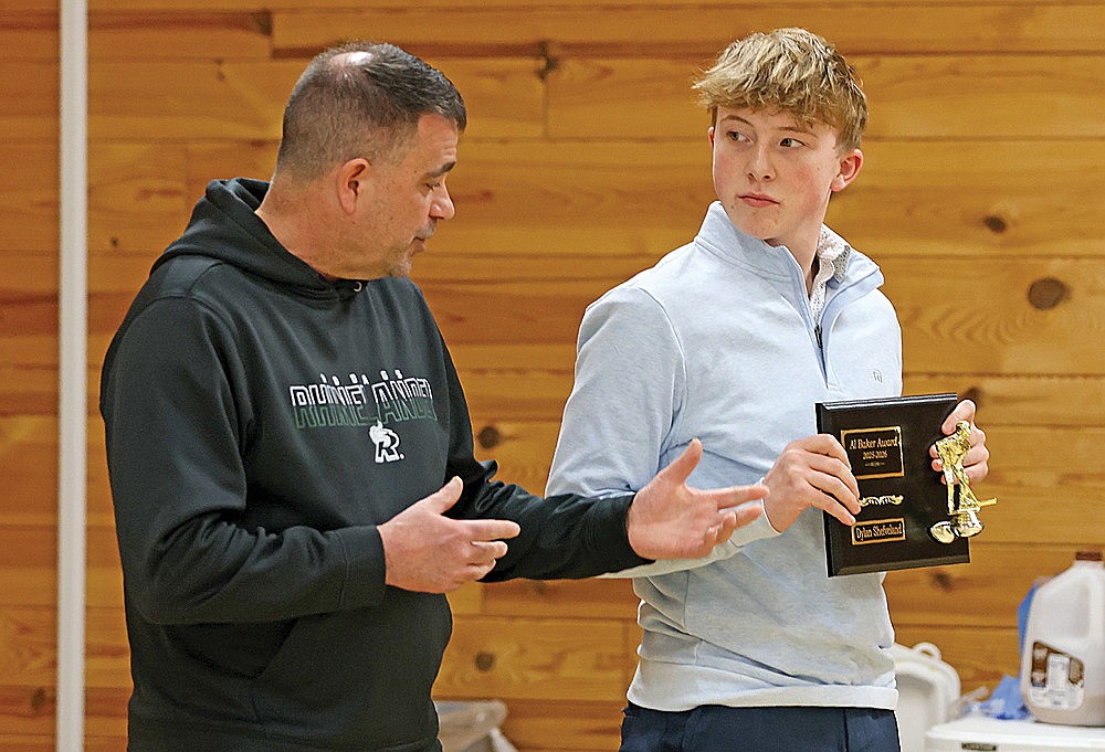 Rhinelander High School boys’ hockey coach M.J. Laggis presents Dylan Shefveland, right, with the Alfred O. Baker Outstanding Hockey Player Award during the team’s banquet at the Cedric A. Vig Outdoor Classroom Monday, March 9. (Bob Mainhardt for the River News)