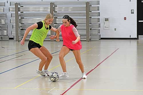 Kasey Wise, left, and Addie Hagen battle for the ball during the first day of tryouts Monday, March 23 at the Lakeland Union High School fieldhouse in Minocqua. (Photo by Brett LaBore/Lakeland Times)