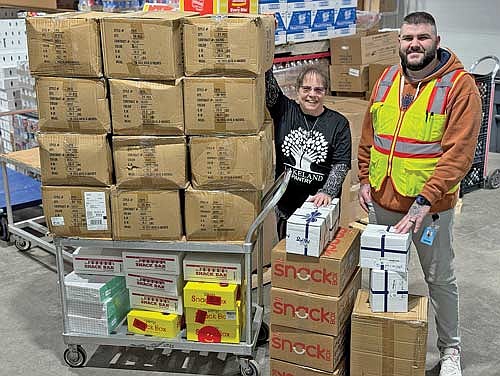 Lorna Springate, director of the Lakeland Pantry accepts the donation of over 300 backpacks from Allen Osman, area manager for Amazon in Weston. (Contributed photograph)