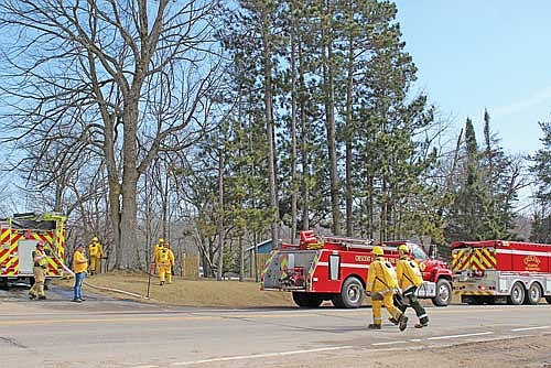 Crescent Volunteer Fire Department firefighters, assisted by units from the Cassian Volunteer Fire Department and Wisconsin DNR, battled a brushfire spreading on the steep hillside behind 7373 U.S.Highway 8 in Woodboro Township on Sunday, March 29. (Photo by Ardith Carlton/River News)