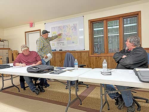 Lynne town supervisor Jeff Brown, center, goes over items on a map during a special meeting of the Lynne town board on Wednesday, April 8. Also pictured is town supervisor Tim Karau. (Photo by Brian Jopek/Lakeland Times)