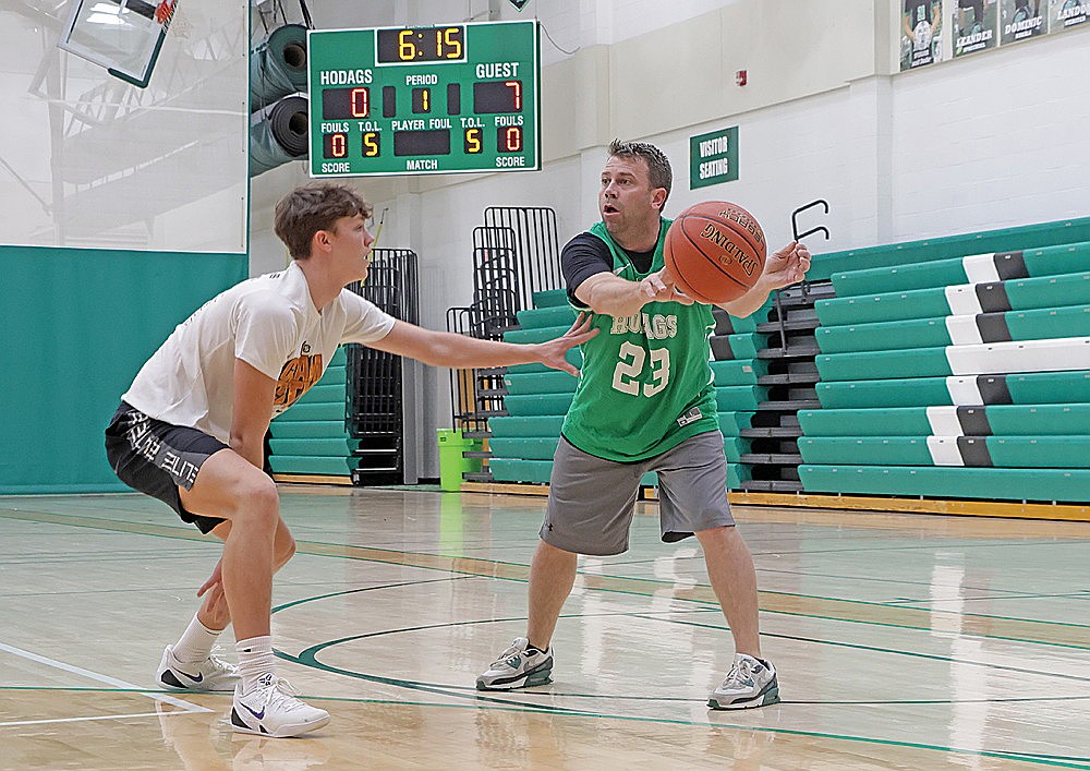 Rhinelander High School activities director Brian Paulson dishes a no-look pass guarded by Jatyn Barkus during the first half.