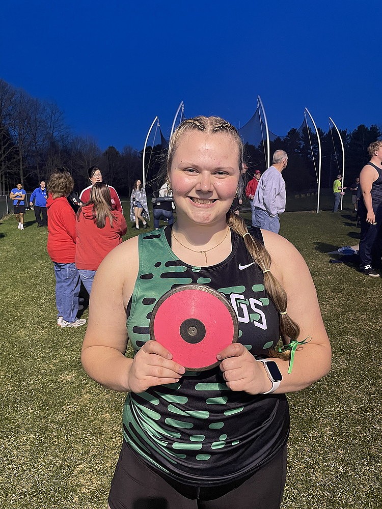 Rhinelander High School senior Libbey Buchmann poses with the disc she used to break her own school record during the Marathon Invitational track meet in Marathon Thursday, April 16. Buchmann, on her 18th birthday, won the discus competition with a toss of 135 feet, 1 inch — breaking her previous school record set in May 2024 by four inches. (Jeremy Mayo/River News)
