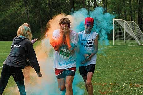 In this May 17, 2025 file photo, Tommy Eades, left, and Henry Schmitz, both of Rhinelander, try to shield themselves from a chalk station during the HOSA Color Run at Rhinelander High School. The fourth annual event is set for Saturday, May 16. (Photo by Jeremy Mayo/River News)