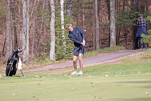 Davis Kock chips the ball towards the green during the fourth Great Northern Conference meet Friday, May 8 at Eagle River Golf Course. Kock placed seventh individually with a 79. (Photo by Bob Mainhardt for the River News)